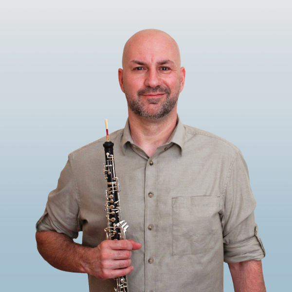 Professional oboist and reed maker holding an oboe