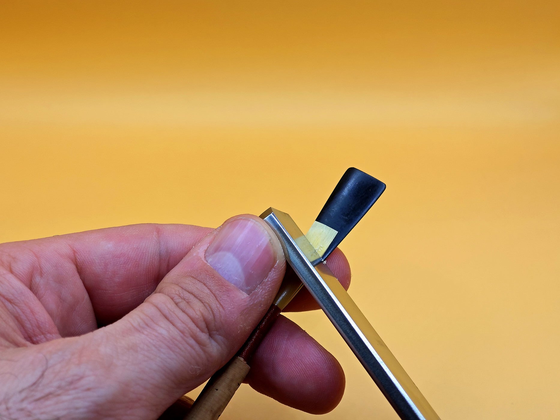 Hand scraping an oboe reed with a reed making knife