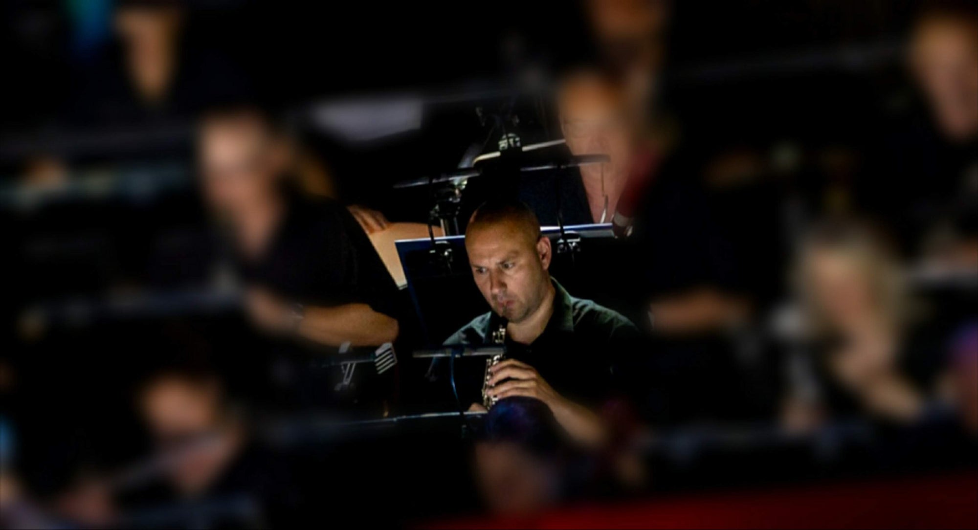 Professional oboist performing with handmade oboe reeds in orchestra